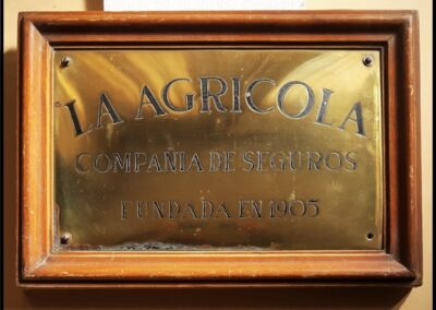 Placa de bronce con marco de madera de La Agrícola Compañía de Seguros S. A.